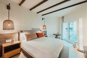 Hotel room with white bedspread on bed