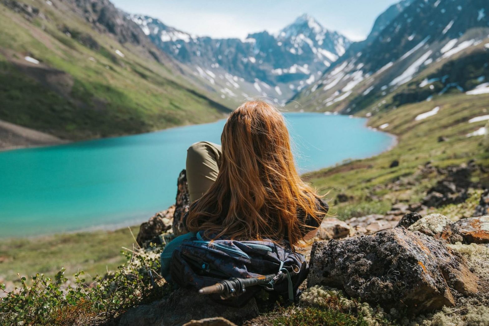 Girl looking at mountains and body. of water