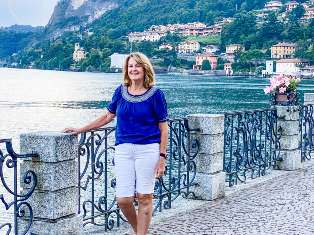 Girl standing in front of lake with white shorts and blue top