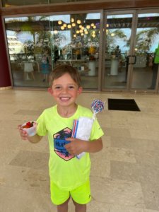 Young boy holding popcorn and candy
