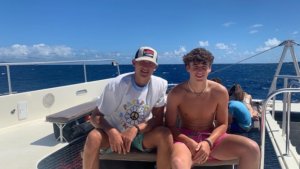 2 boys sitting on sailboat
