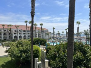 White hotel with red tiles and palm trees around