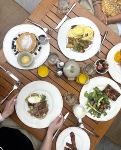 Brown table with white plates containing food