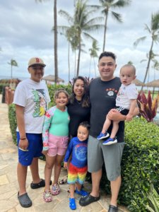 Family standing in front of palm trees