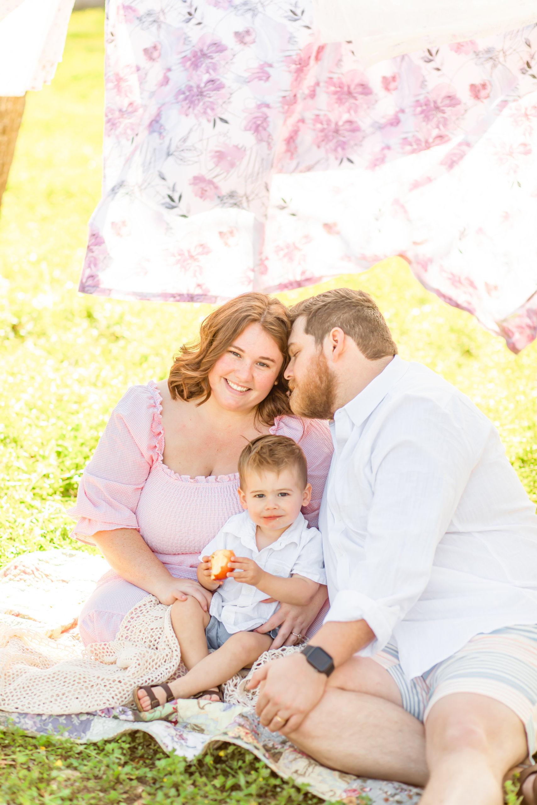 Man, woman and little boy sitting on blanket