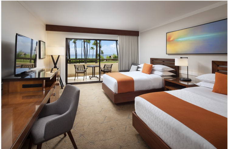 Hotel room with two beds and orange and white covers