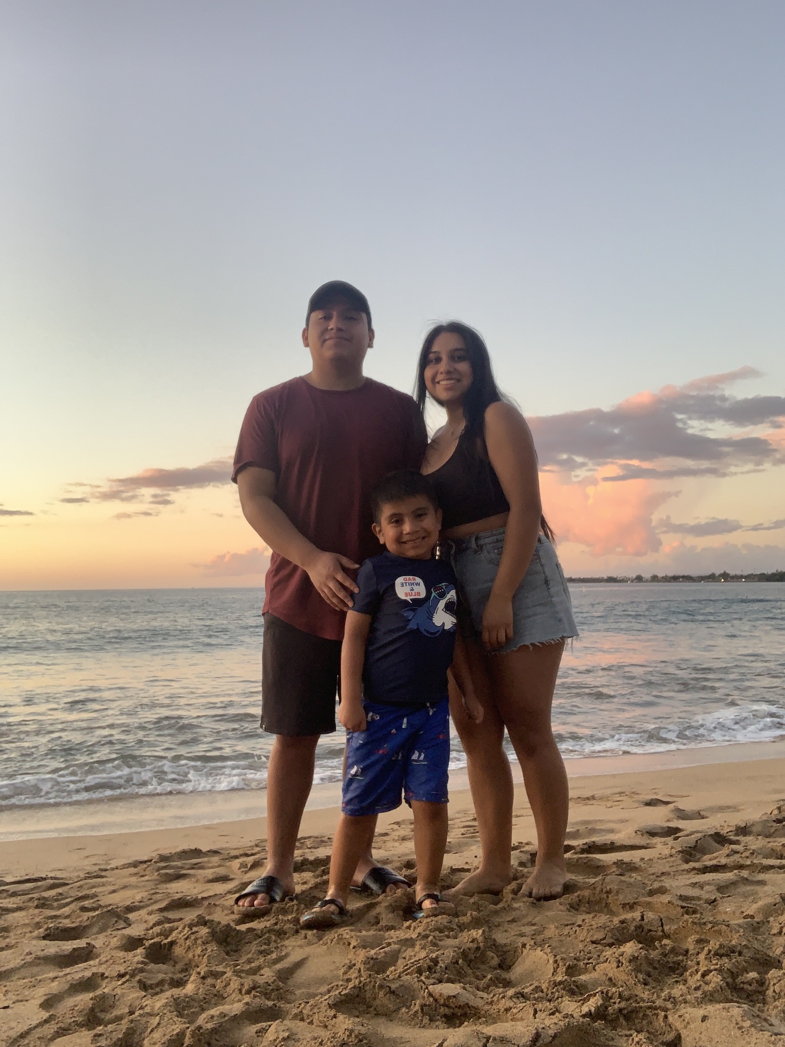 Young family standing on sand