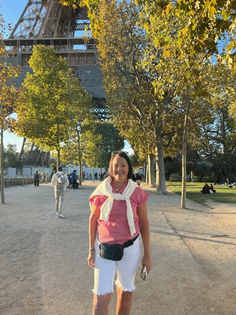 woman in white shorts stand-in in front of large tower