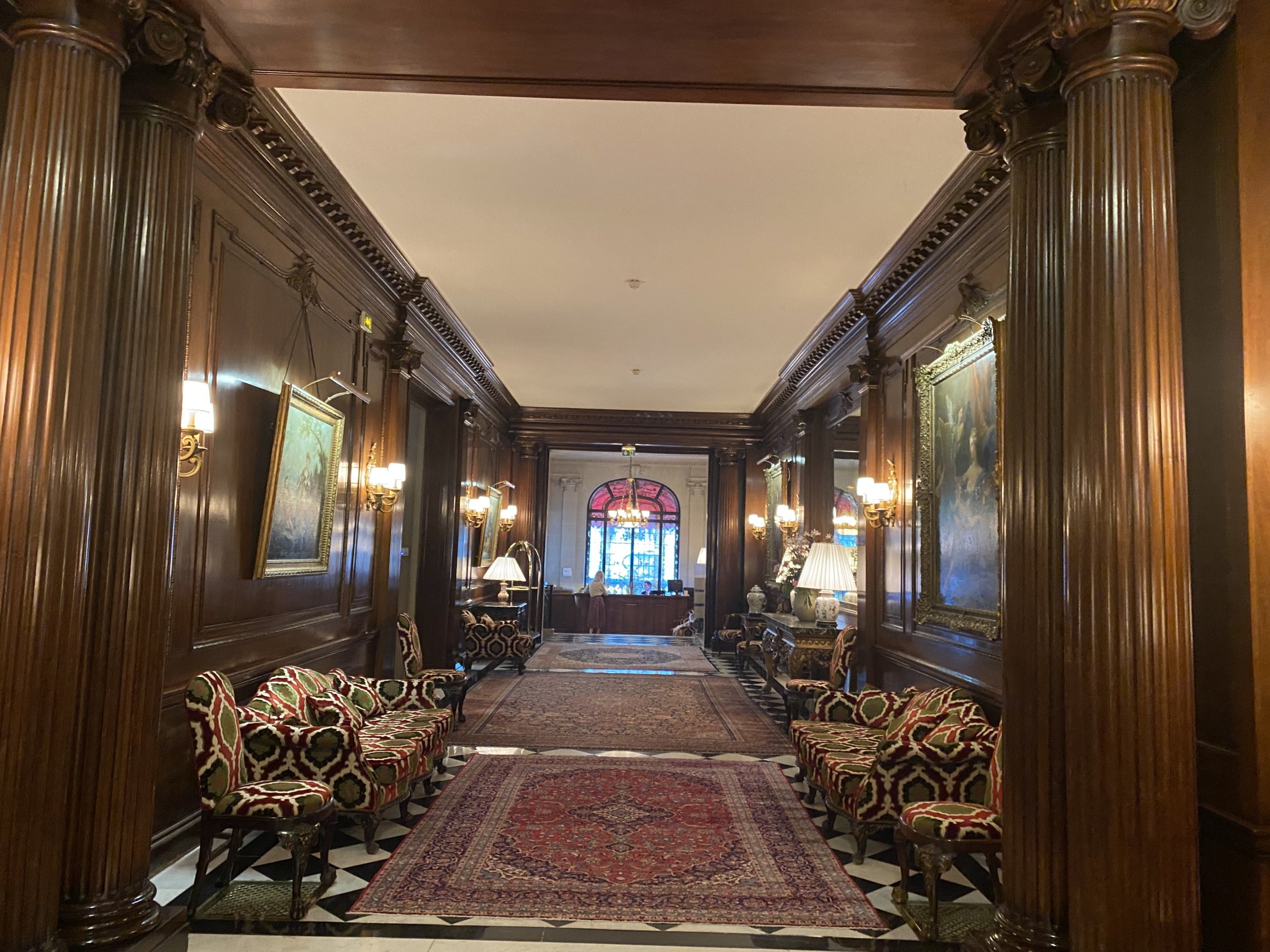 Hotel lobby with red Persian rugs and dark wood walls