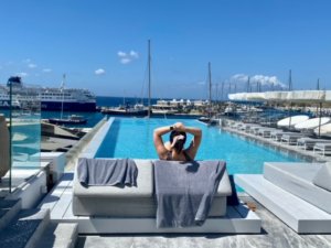 Girl relaxing on lounge chair overlooking pool and marina