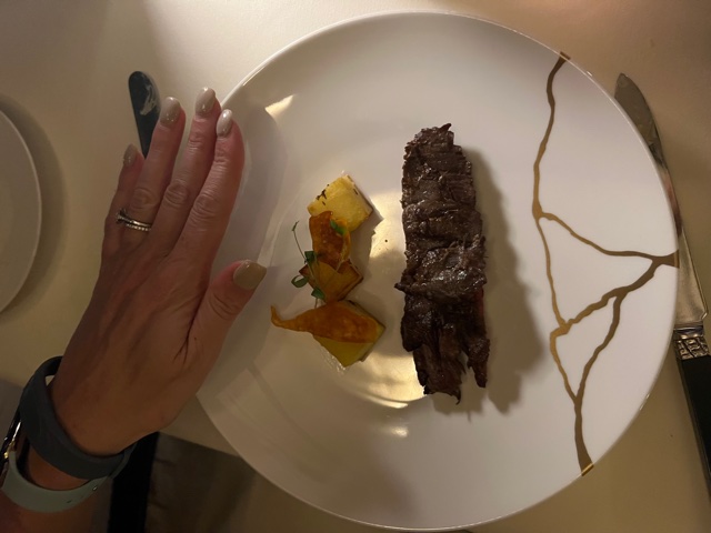 Small steak and 3 potato bites on plate