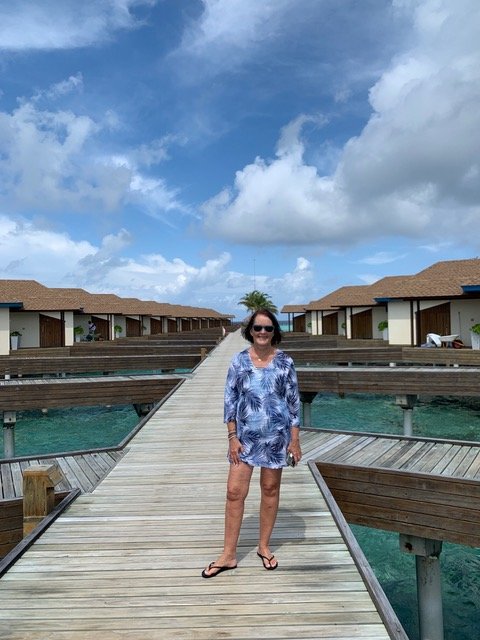 Woman standing in front of overhead bungalows.