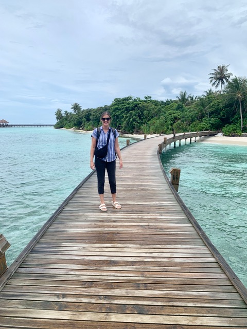 woman standing on wood bridge iover turquoise water