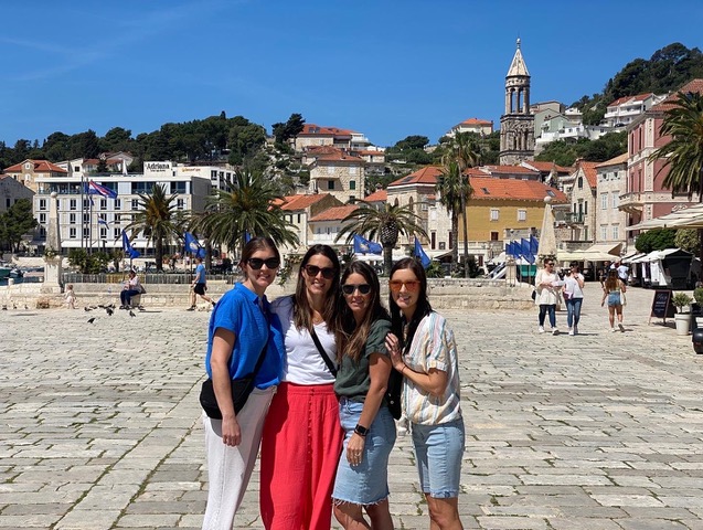 Four women standing in square of town