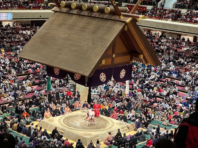 Large men wrestling in ring.