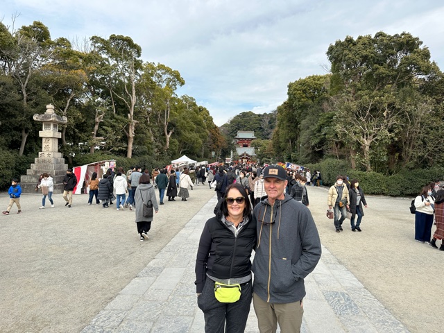 Man and woman standing in front of shrine.