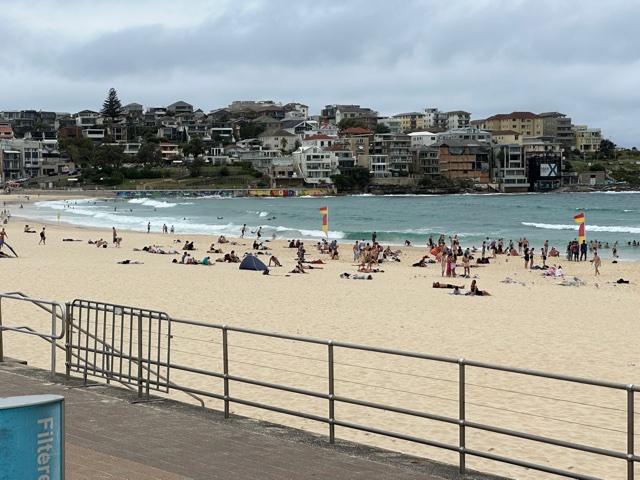 Sand and blue water with people on the sand