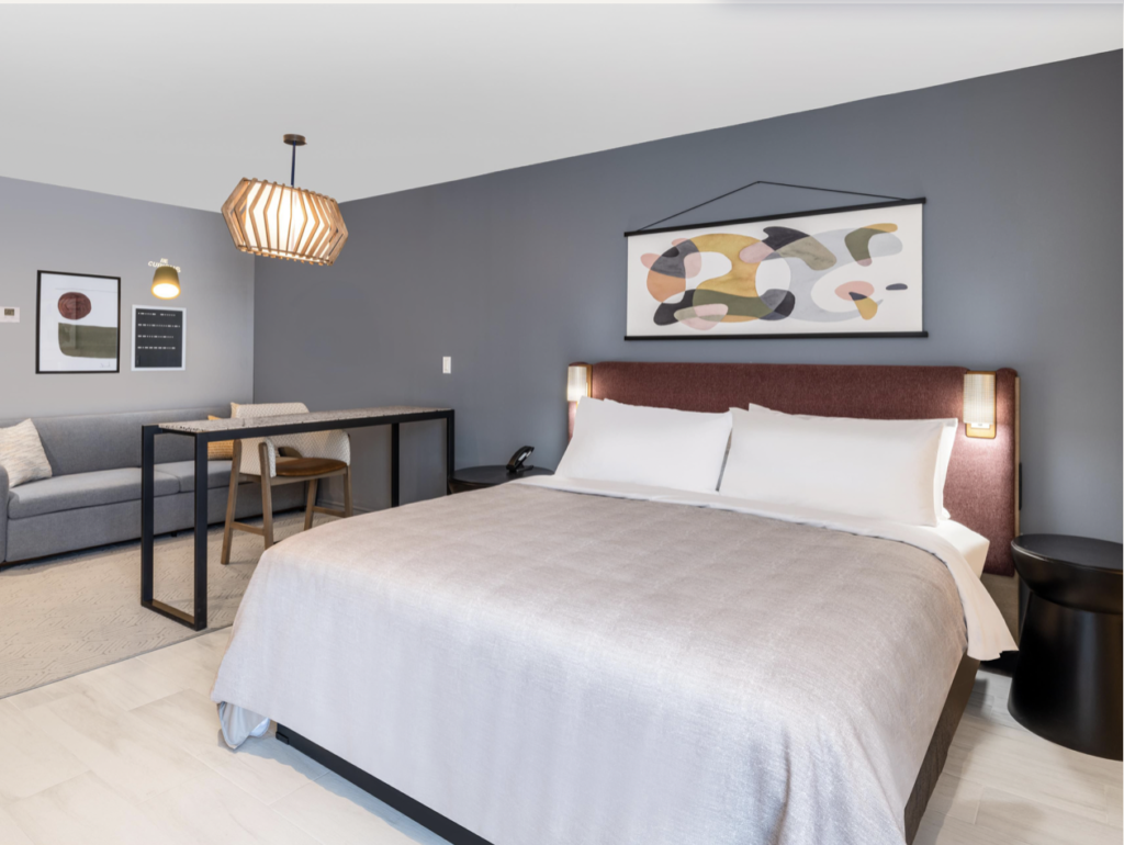 Hotel room with grey walls and grey couch..