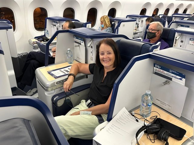 Woman sitting on airplane in business class seat