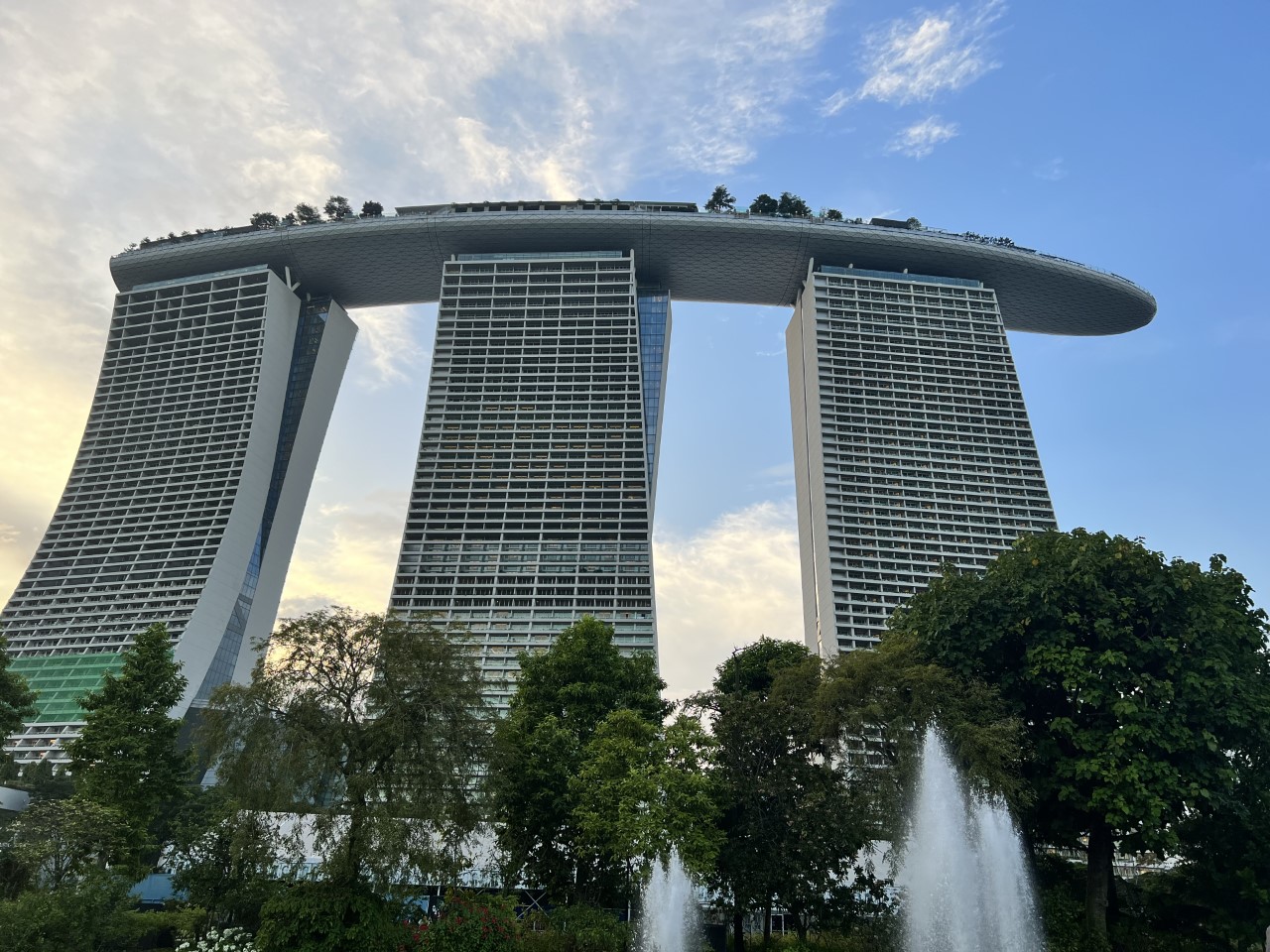 three towers with greenery below them