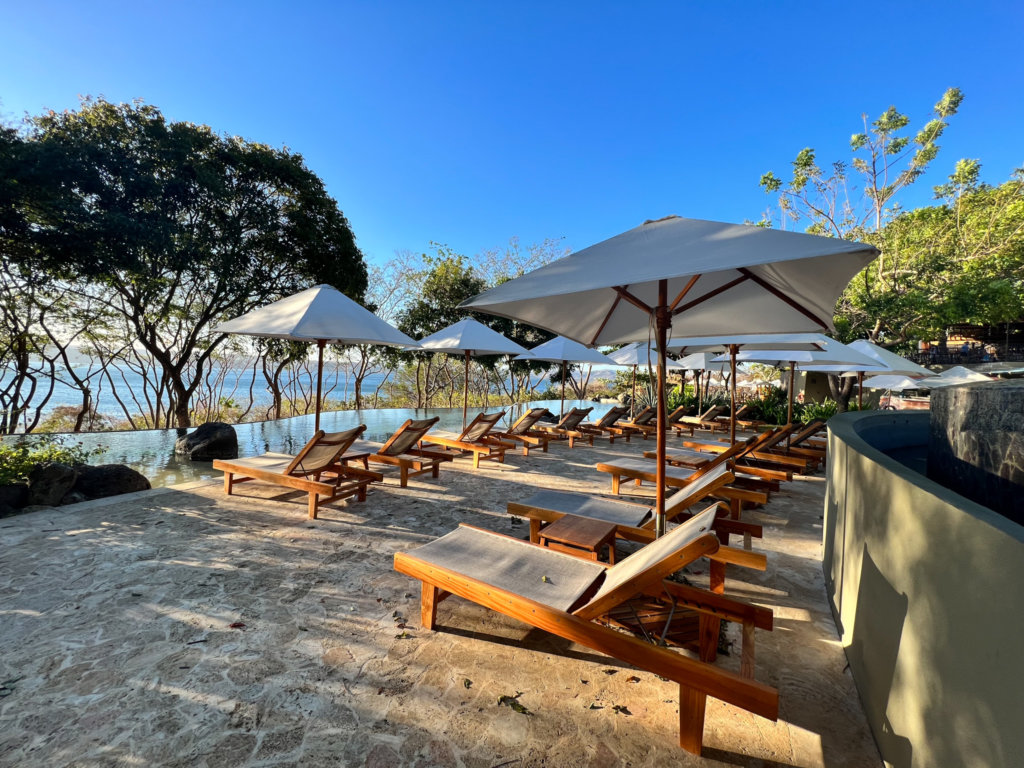 Lounge chairs and umbrellas on sand