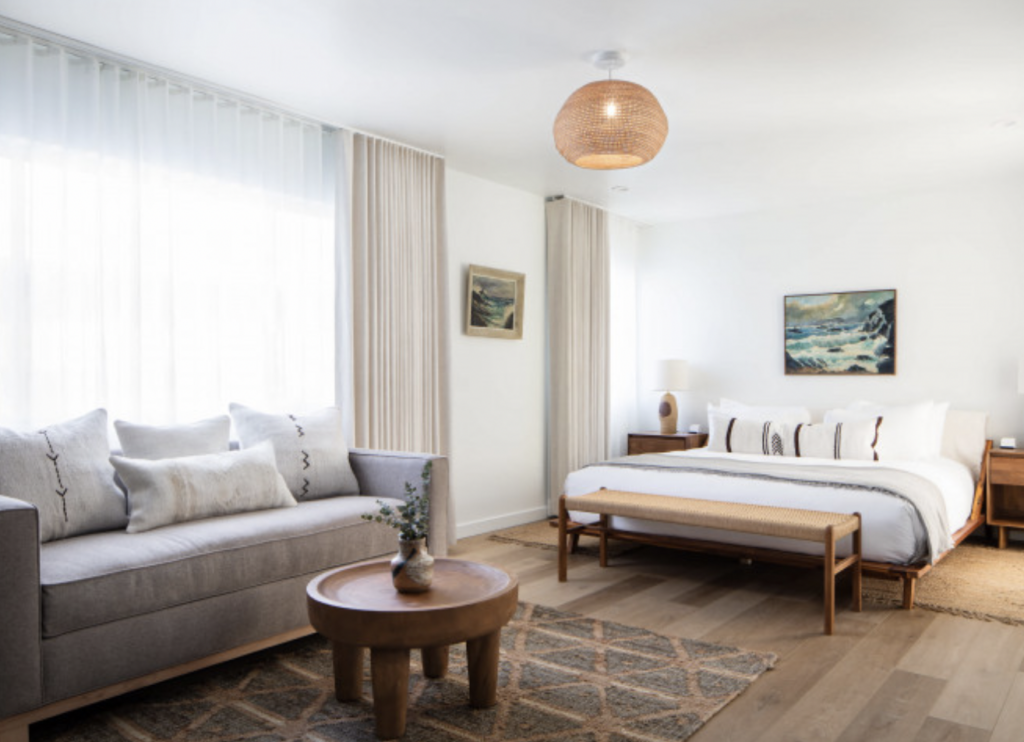 Hotel room with light walls and beach theme.