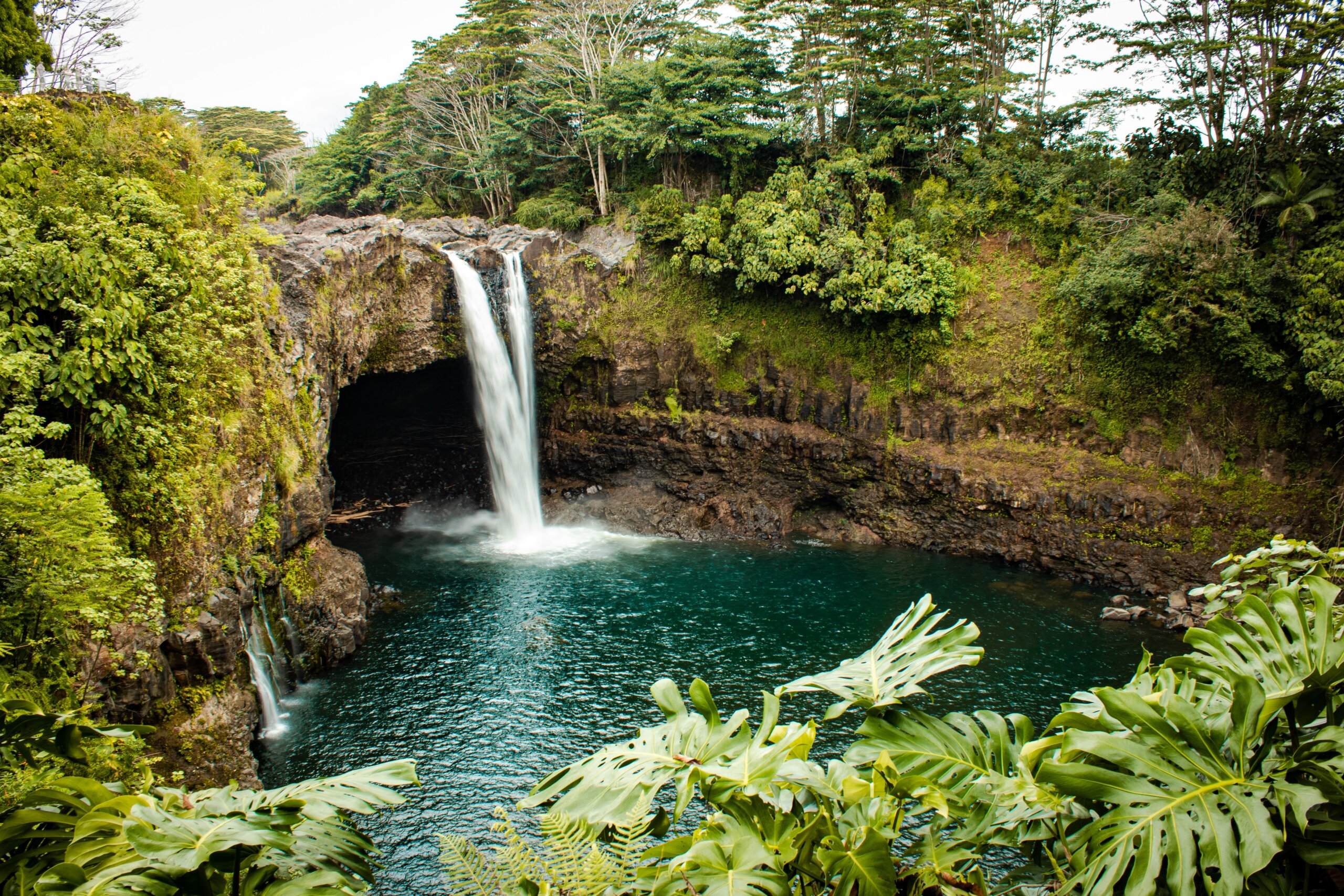 Waterfall into green pool of water