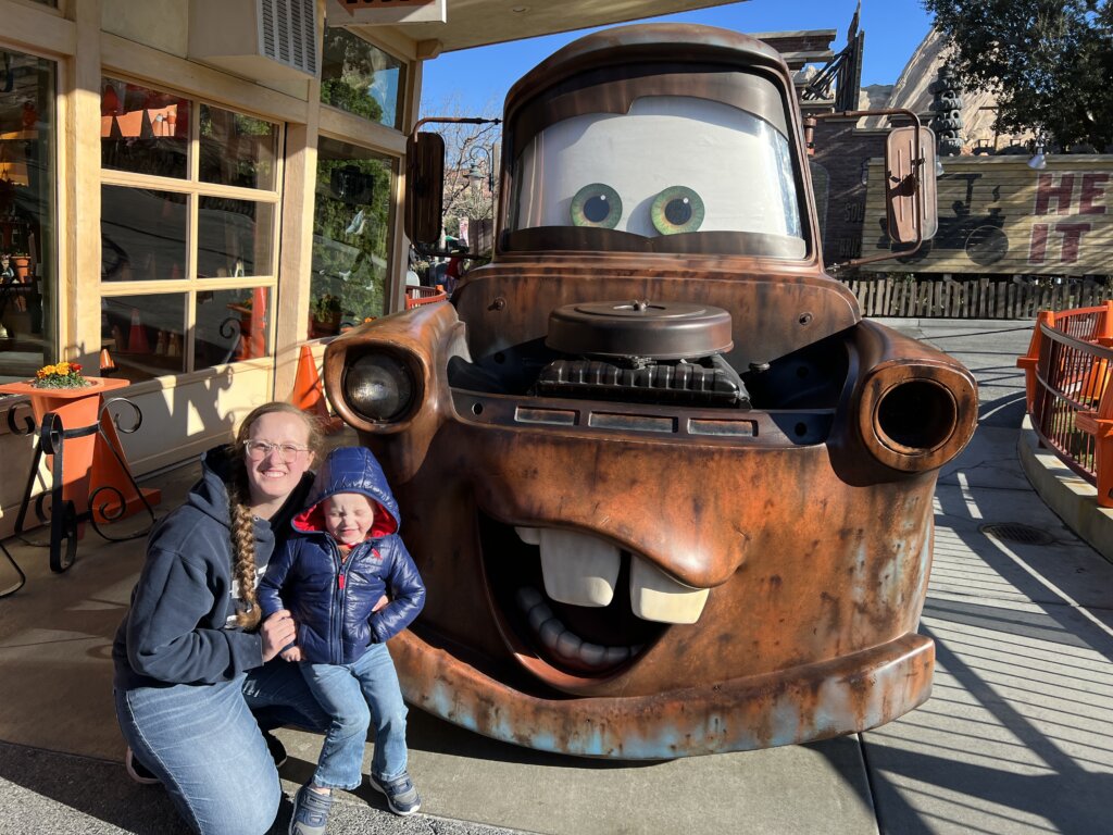 Woman with small boy near car at amusement park.