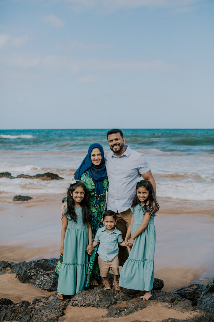 Man, woman and three children on beach.