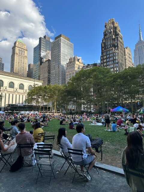 People sitting on chairs and ground in park