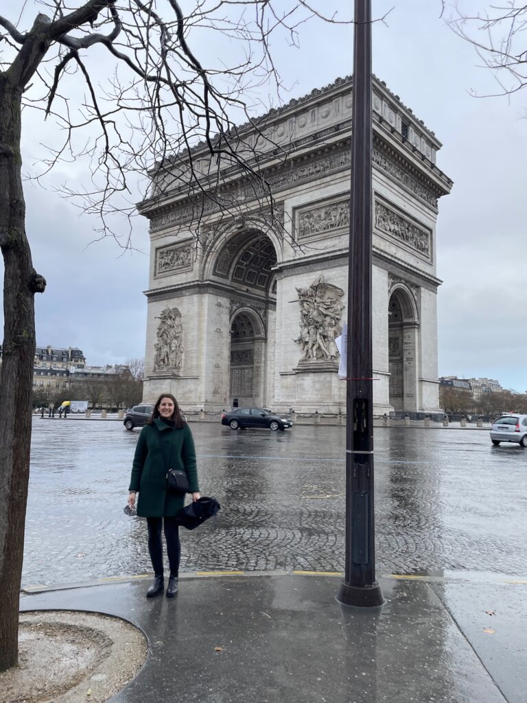 Woman standing on street near large arch