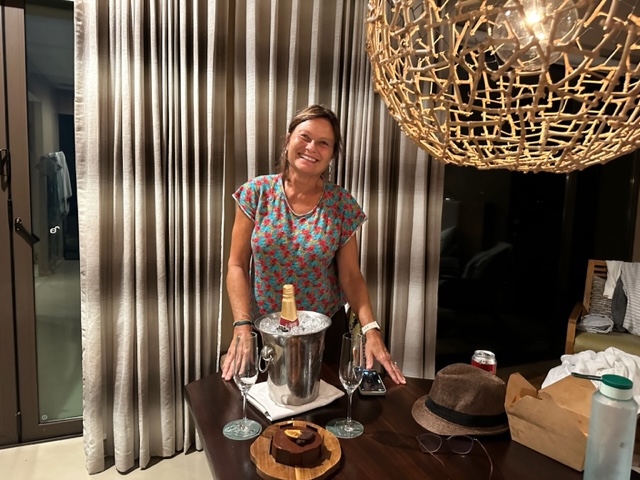 Woman standing in front of ice bucket and small cake.