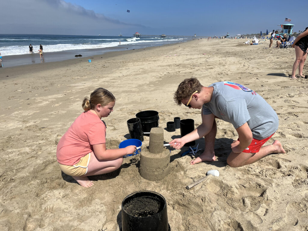 Boy and girl building sand castle in the sand.