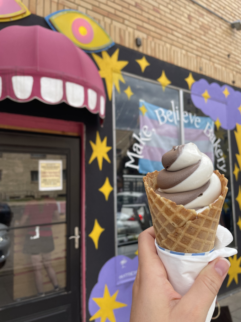 Brown and white swirled ice cream in front of store called Make Believe.
