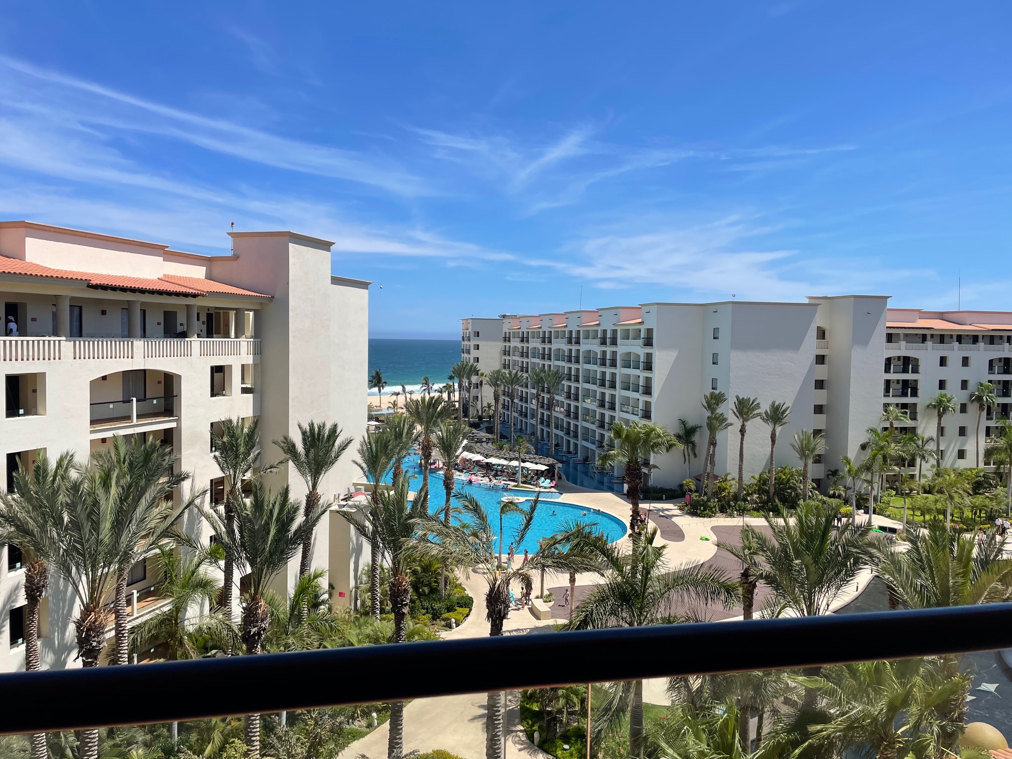 White hotel with blue pool near ocean