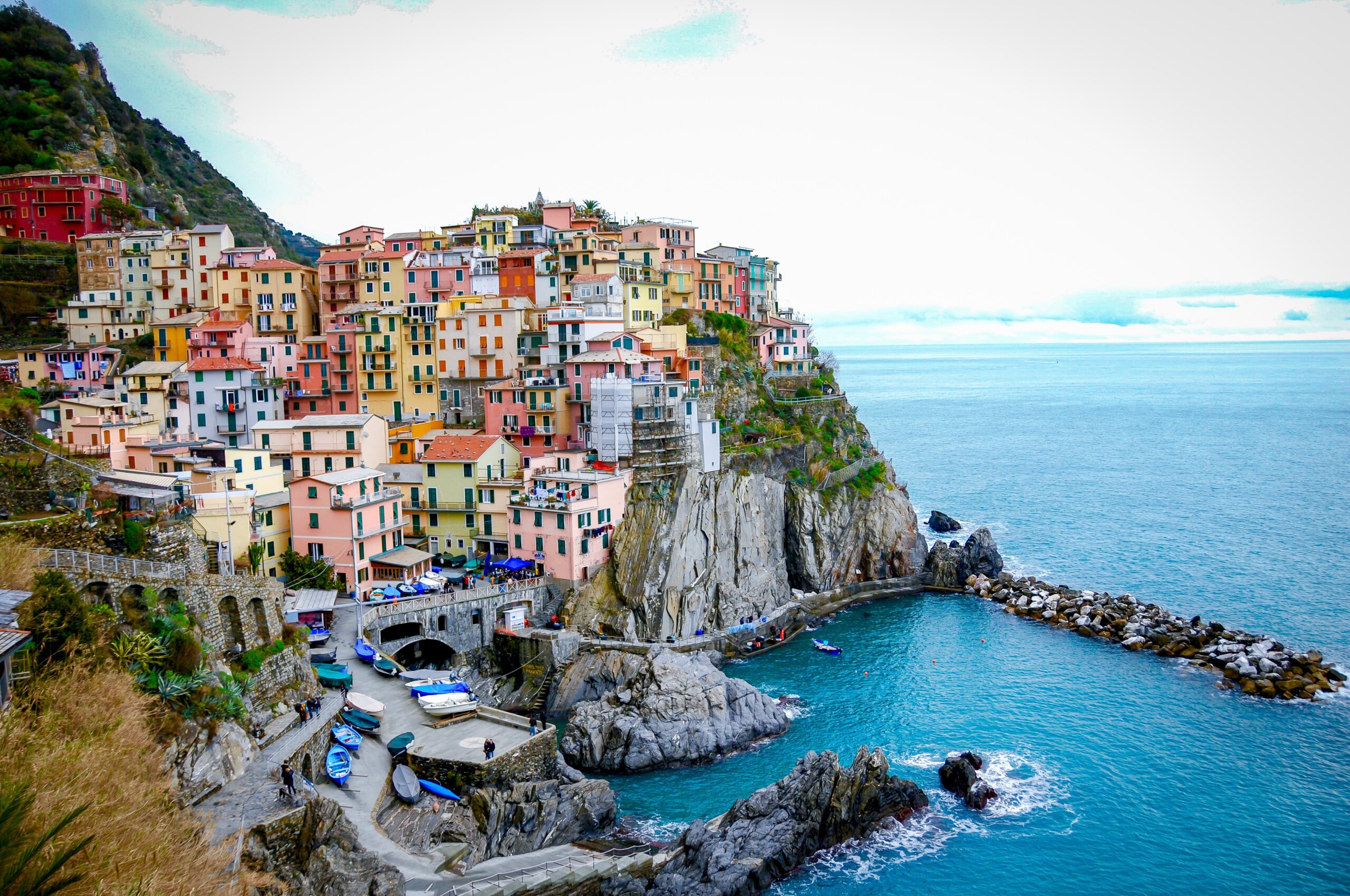 Town of bright colored houses set on cliff with blue water surrounding it