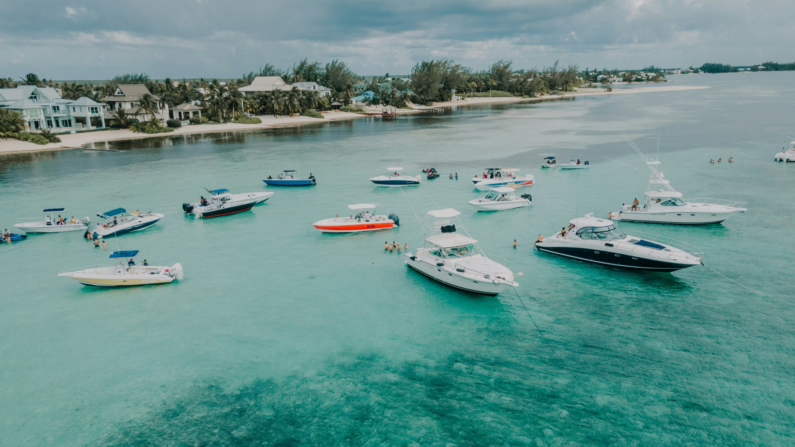Crystal clear turquoise beach with boats in water