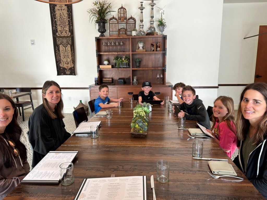 Family sitting around brown table at restaurant.