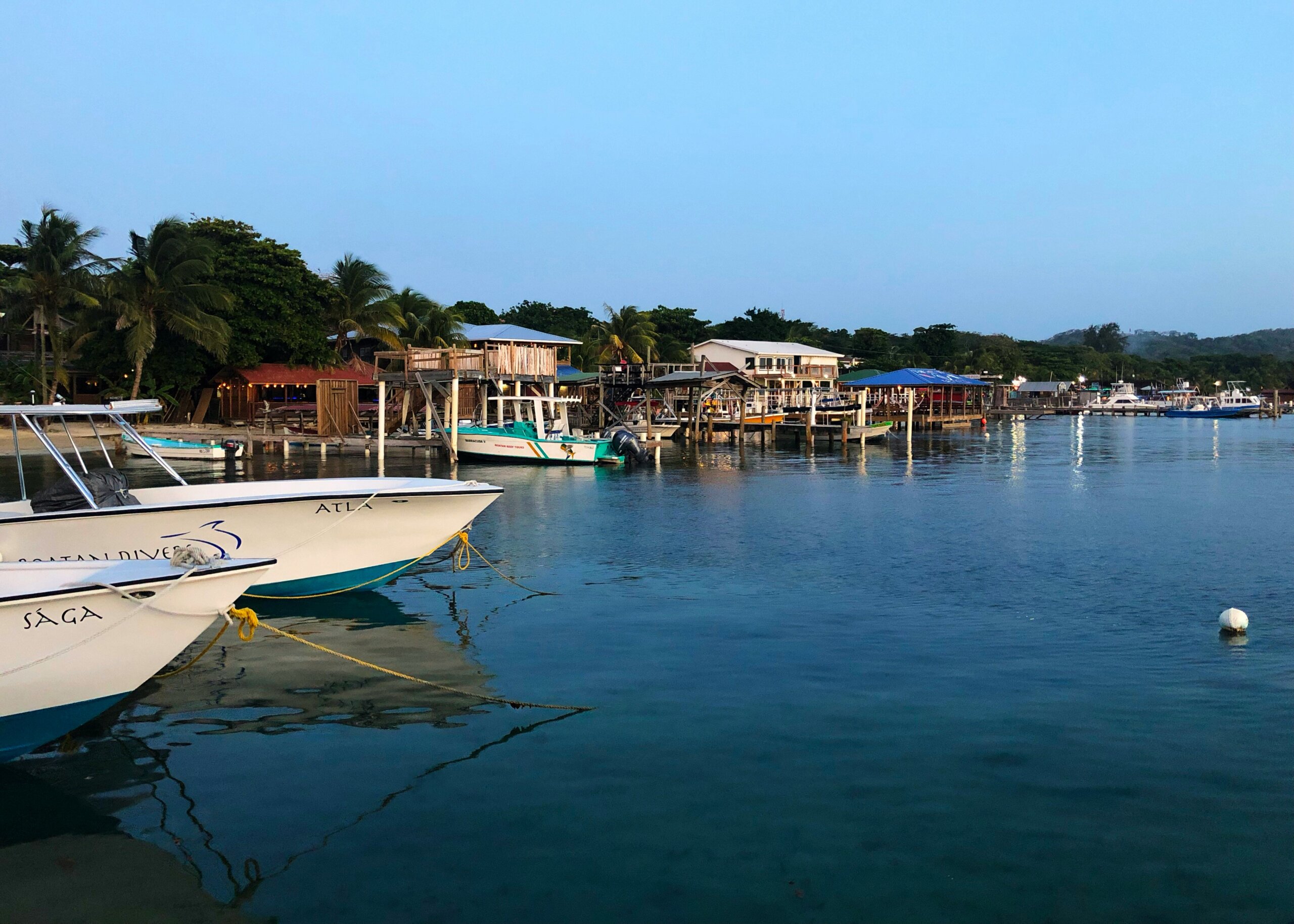 Boats in blue water near pier
