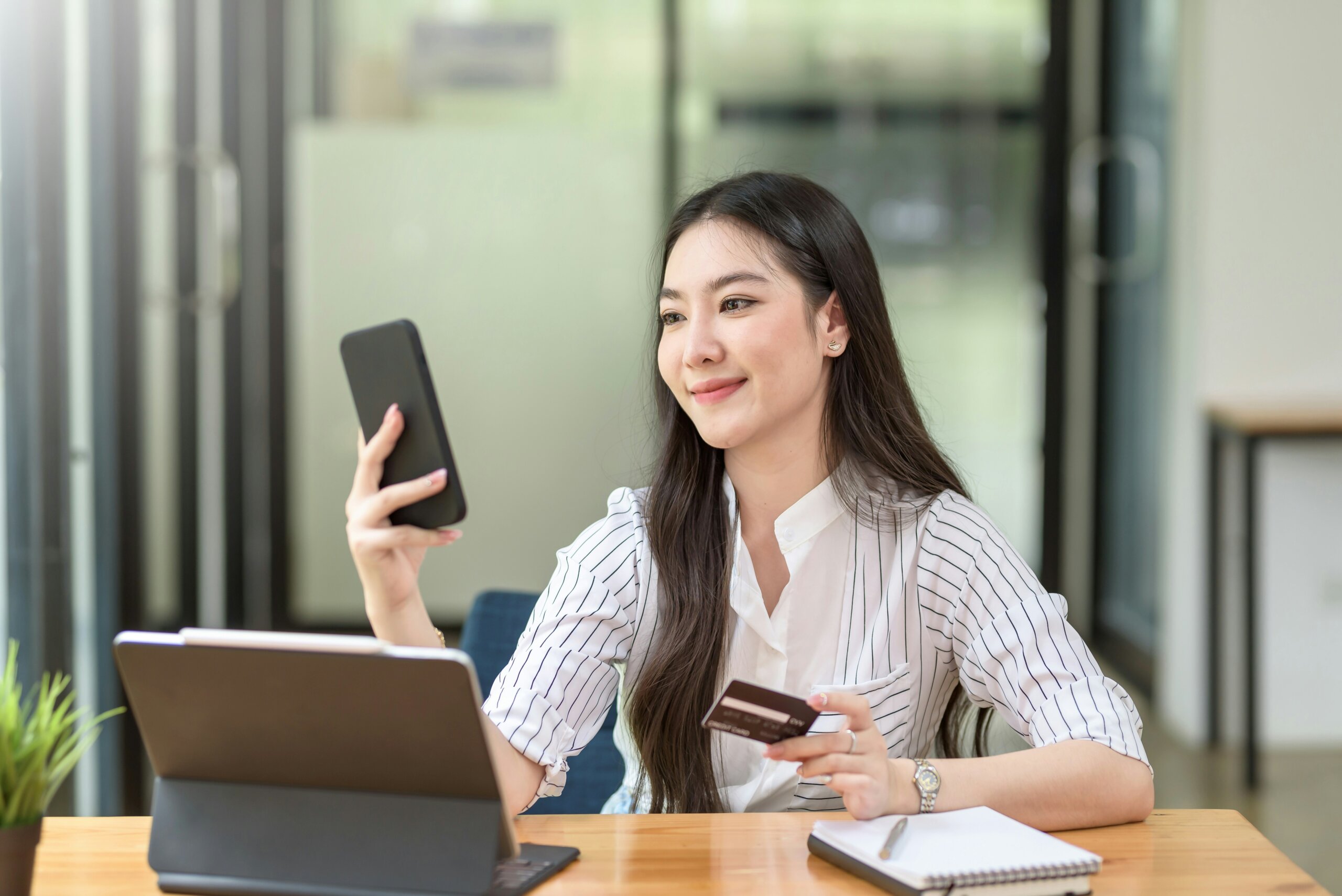 Girl holding phone and credit card.