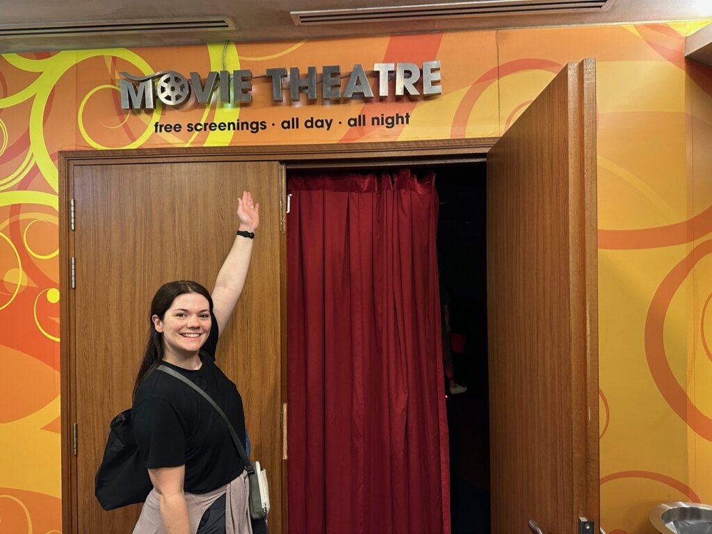 Woman pointing to a movie theater sign.