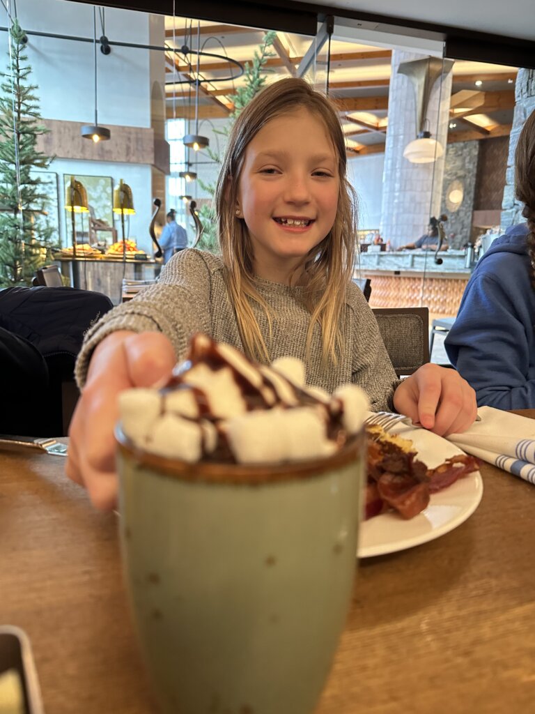 Young girl showing her hot chocolate.