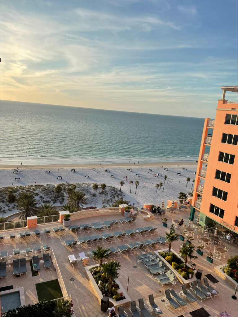 View of beach with pink hotel at the side.