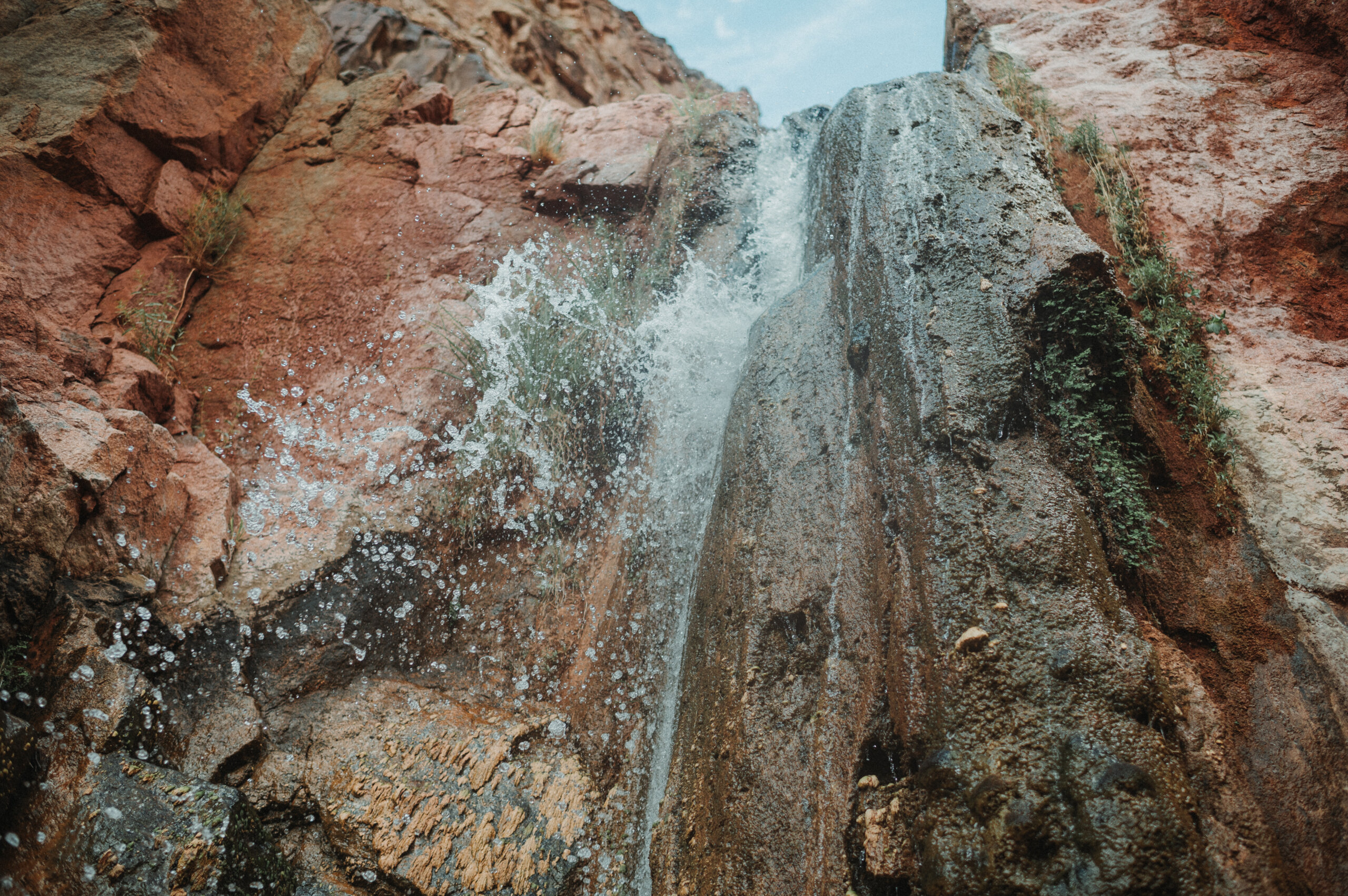 Small waterfall in a red rock gorge.