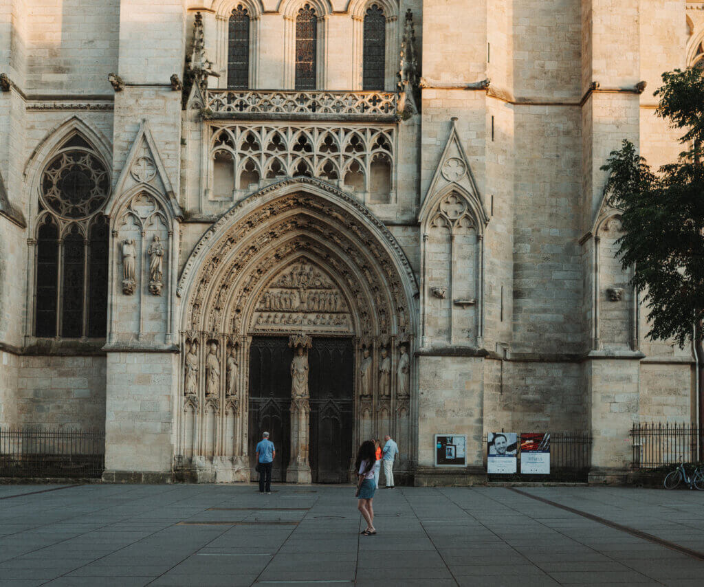 Woman standing in front of old cathedral in Bordeaux, France