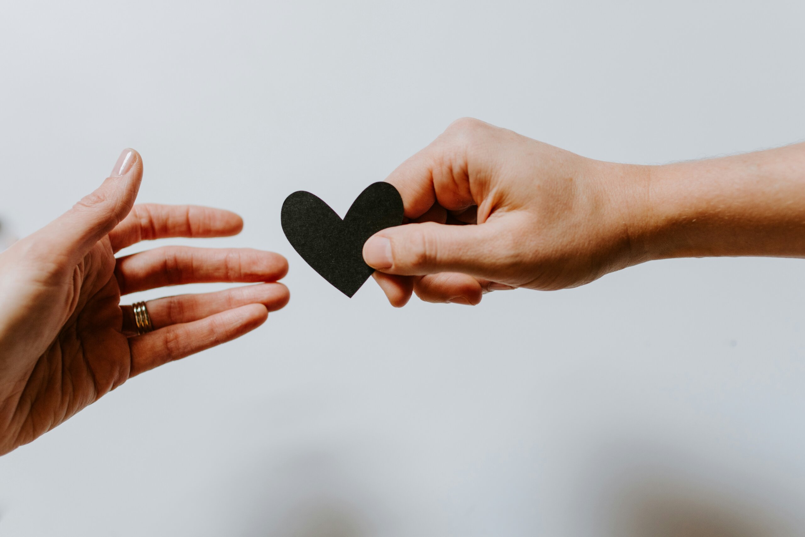 A man's hand handing a woman's hand a heart shape