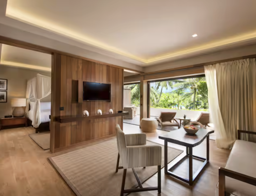 Spacious hotel suite with floor-to-ceiling windows, a separate sitting area and bedroom