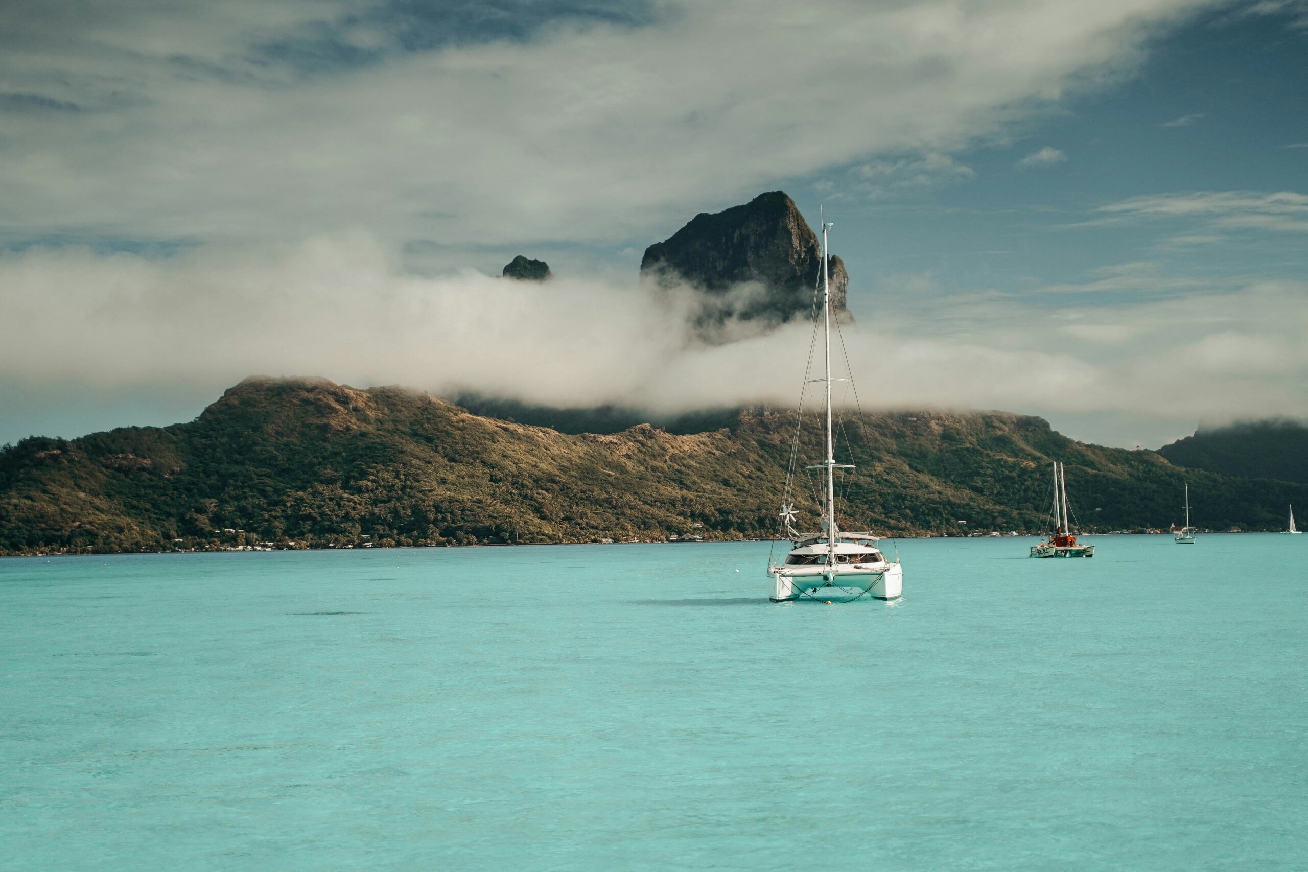 A small boating sailing on the milky blue water of French Polynesia