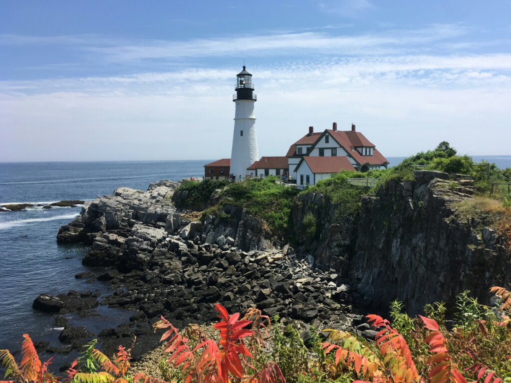 Lighthouse on a hill and fall foliage in the foreground