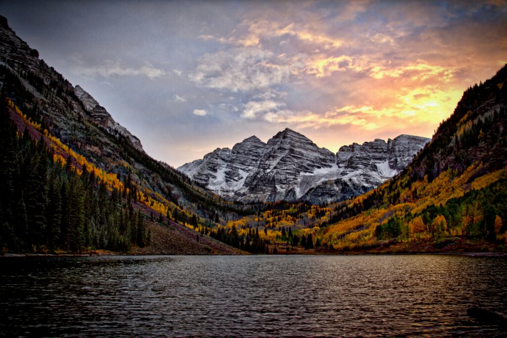 Maroon Bells in Colorado at sun down and surrounded by fall colors